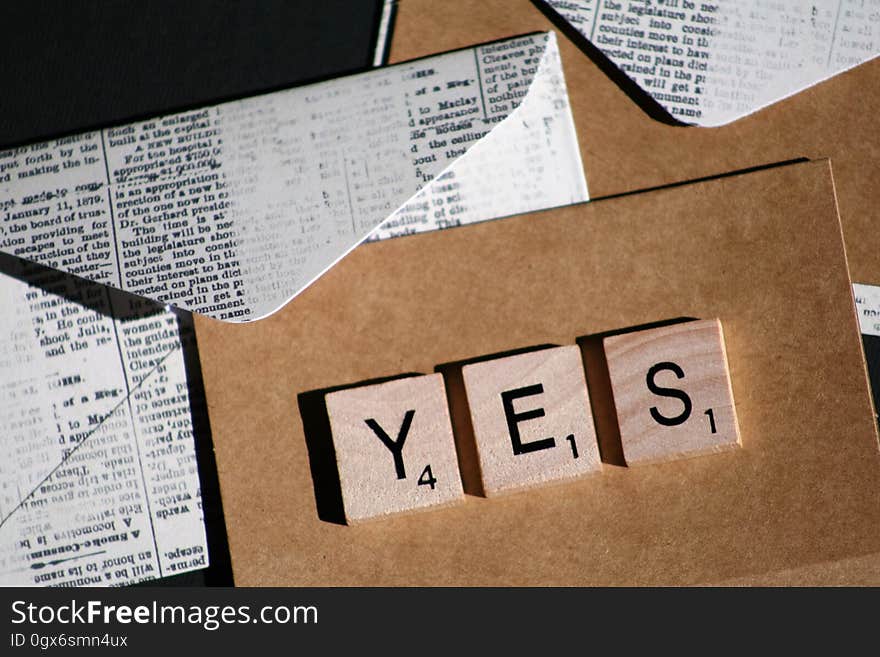 Yes spelled in Scrabble pieces on cardboard with folded print envelopes. Yes spelled in Scrabble pieces on cardboard with folded print envelopes.