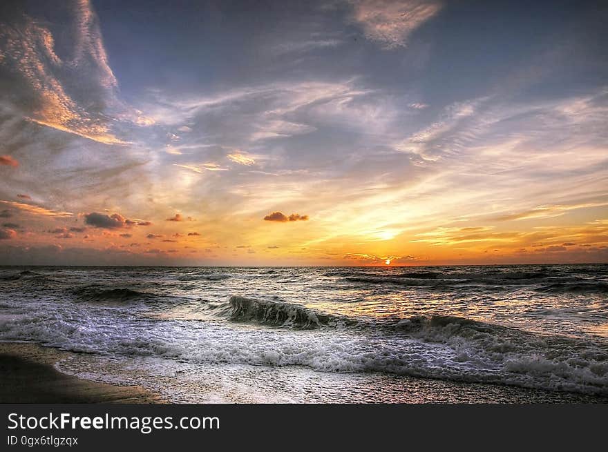 A sunset on the sea with waves coming ashore. A sunset on the sea with waves coming ashore.