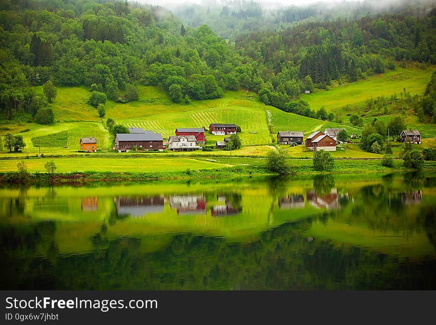 A landscape with farms and hills near a lake. A landscape with farms and hills near a lake.