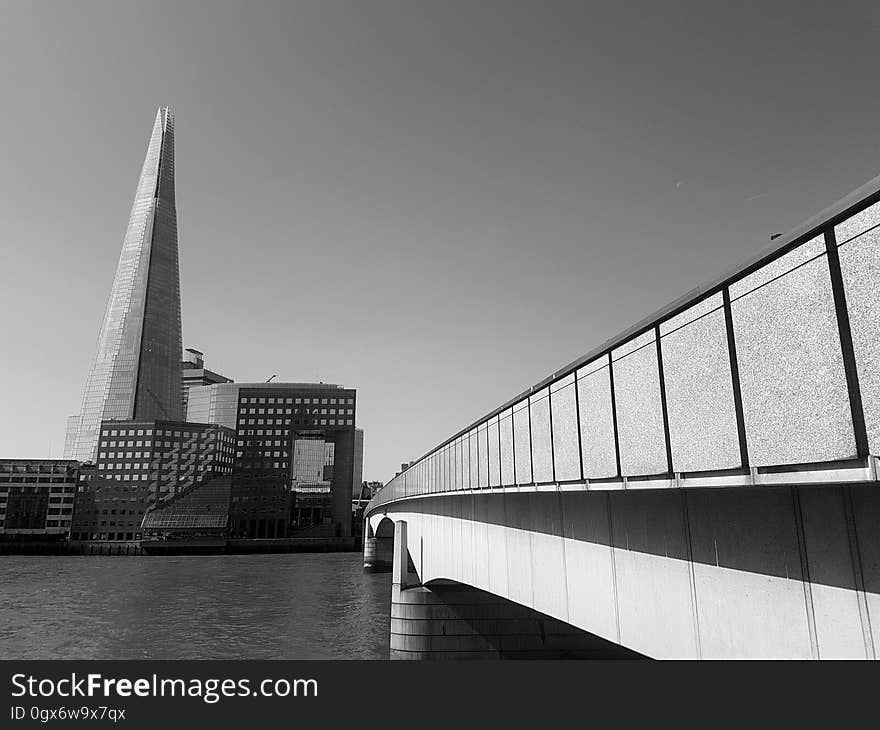 A skyscraper seen from near a bridge in black and white. A skyscraper seen from near a bridge in black and white.