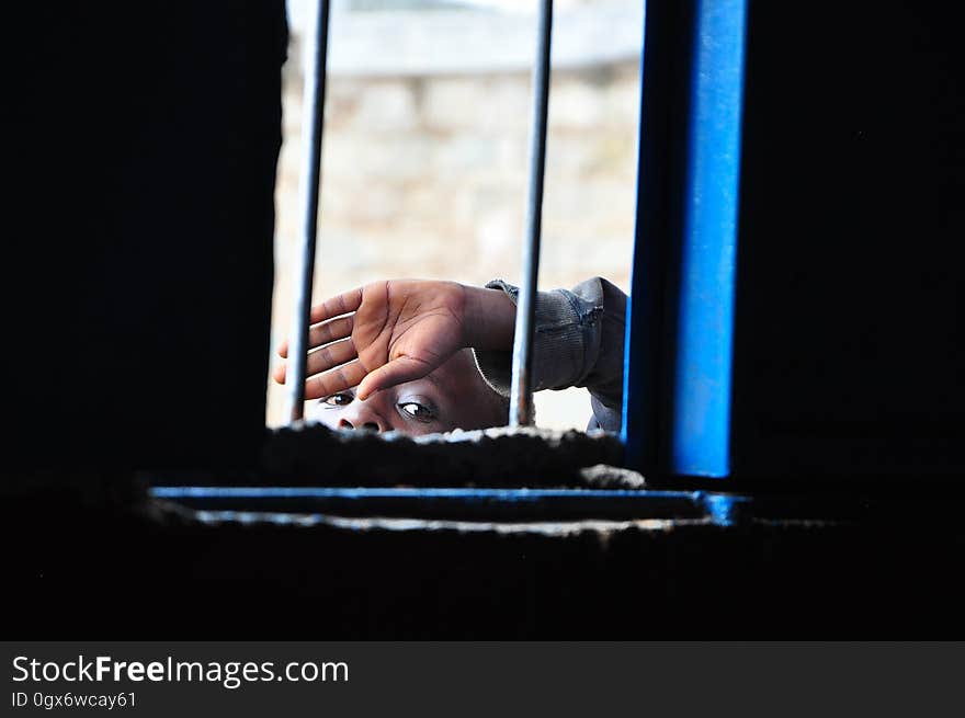 Face and hand of person peeking through window. Face and hand of person peeking through window.