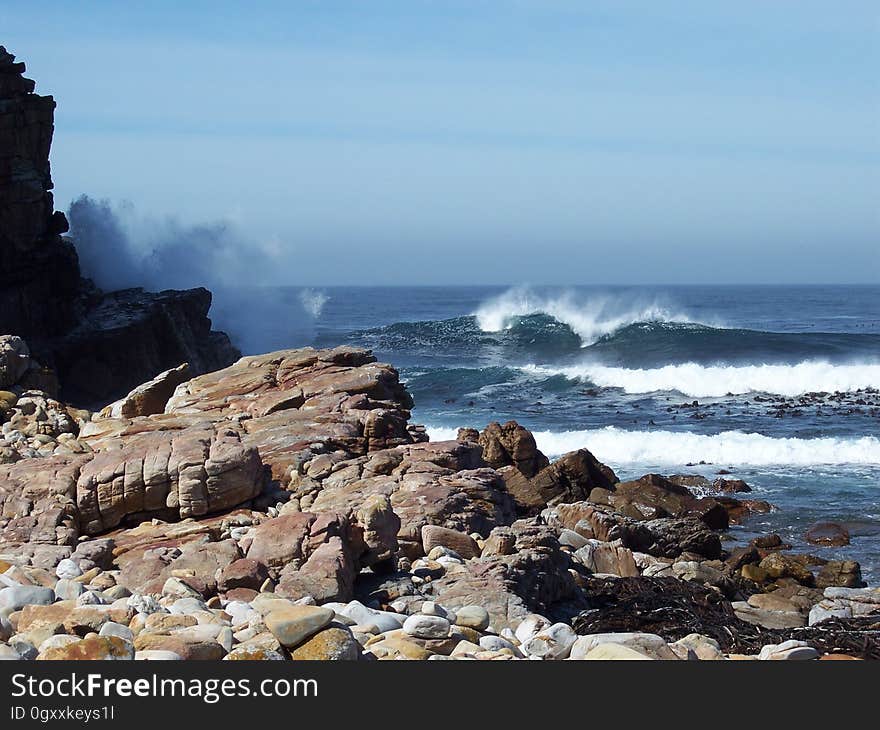 A rocky coast with waves coming ashore.