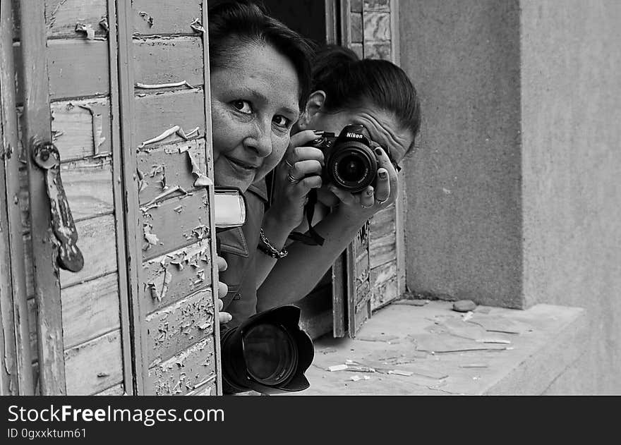 Grayscale Photo of 2 Woman on Window Pane