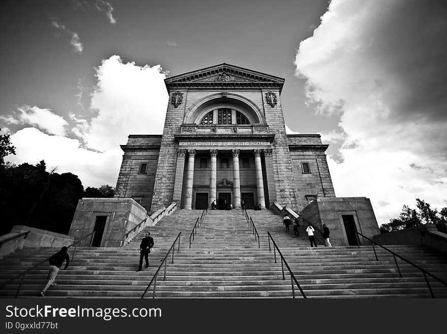 Greyscale Photo of a Building With Walking People