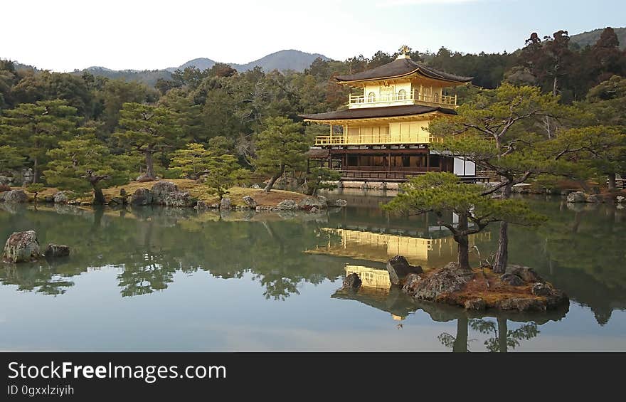 Kinakaku-Ji temple reflecting in waterfront on lake in Kyoto, Japan on sunny day. Kinakaku-Ji temple reflecting in waterfront on lake in Kyoto, Japan on sunny day.