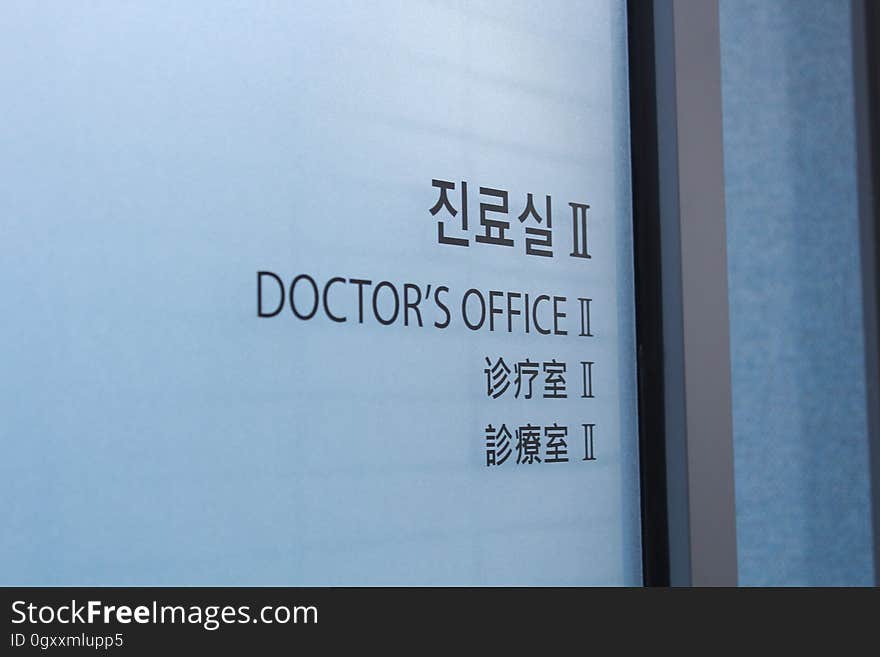 Doctor's Office in black text with Asian language characters on frosted glass door. Doctor's Office in black text with Asian language characters on frosted glass door.