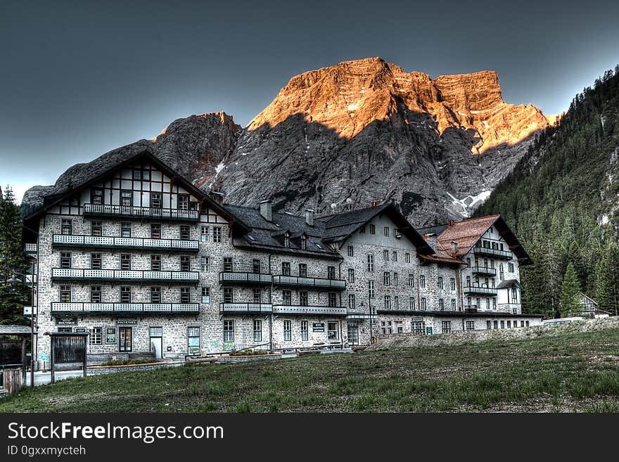 Exterior of country hotel against mountain landscape on sunny day. Exterior of country hotel against mountain landscape on sunny day.