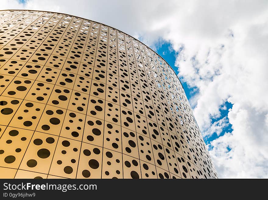 Exterior of wall on contemporary building against white clouds in blue skies. Exterior of wall on contemporary building against white clouds in blue skies.