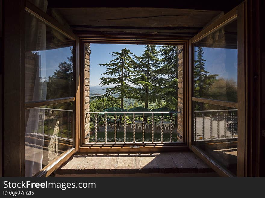 Wooden house built in modern architectural style with large upstairs window looking out upon a group of firs in a large garden. Wooden house built in modern architectural style with large upstairs window looking out upon a group of firs in a large garden.