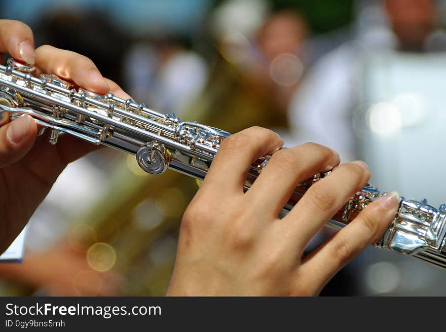 Close up of hands of woman playing flute.