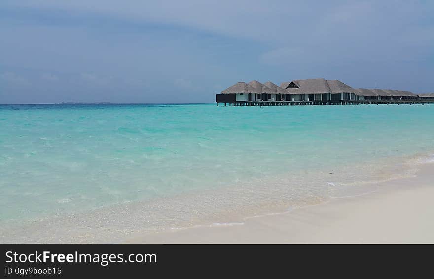 Cabanas on stilts over blue tropical waters on sunny day. Cabanas on stilts over blue tropical waters on sunny day.