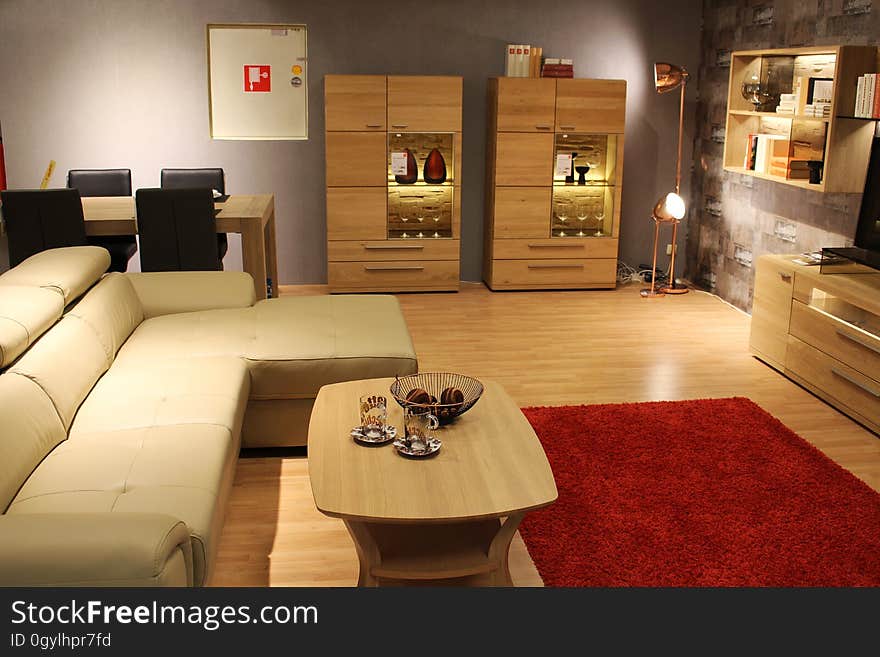 Interior of contemporary living room furnished with leather sofa and wooden tables.