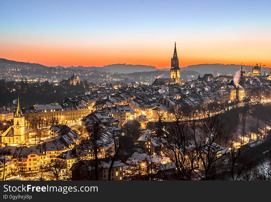 Aerial view of city with castle and church illuminated at sunset. Aerial view of city with castle and church illuminated at sunset.