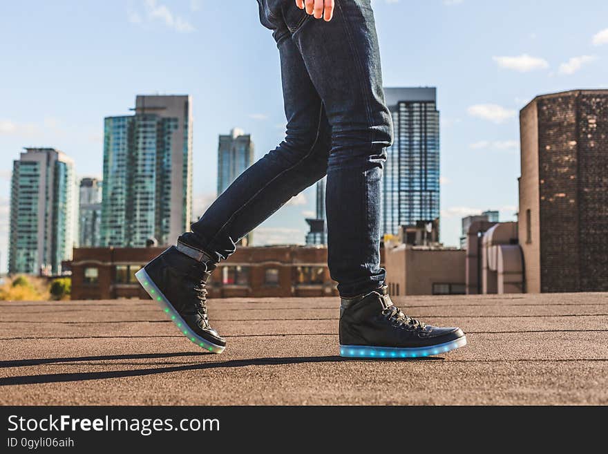 A man walking on roof with shoes with blue LED lights on the soles. A man walking on roof with shoes with blue LED lights on the soles.