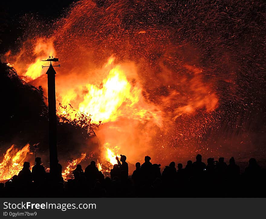 Silhouettes of people looking at a blazing fire. Silhouettes of people looking at a blazing fire.