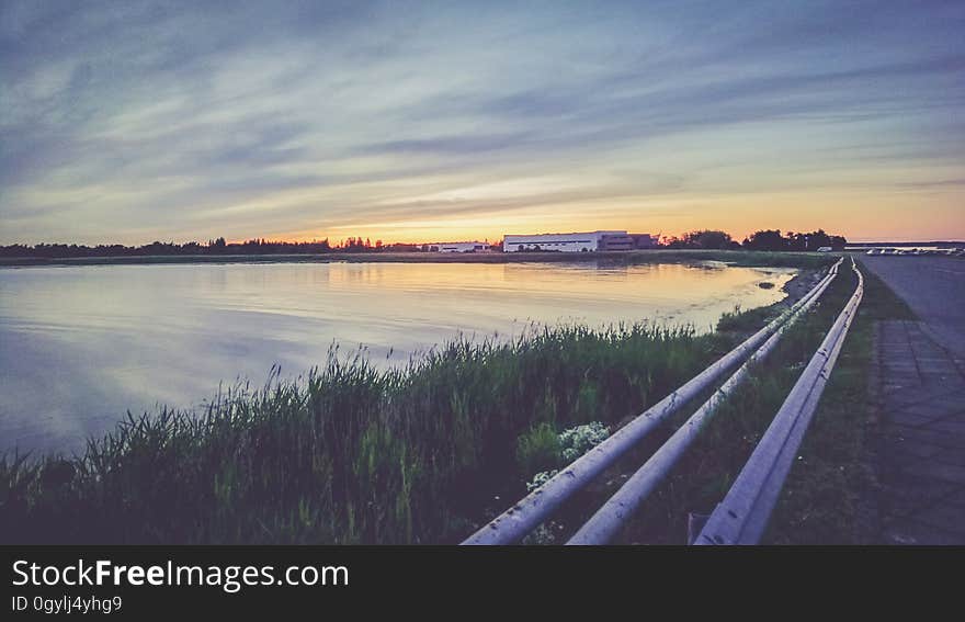 Highway receding past lake at sunset. Highway receding past lake at sunset.