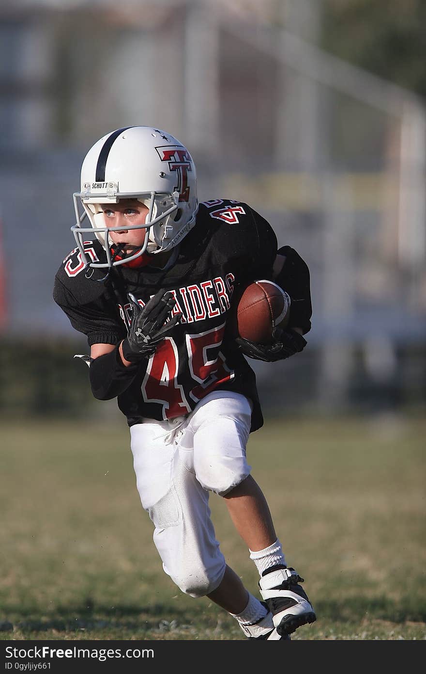 An American football player running while carrying the ball.