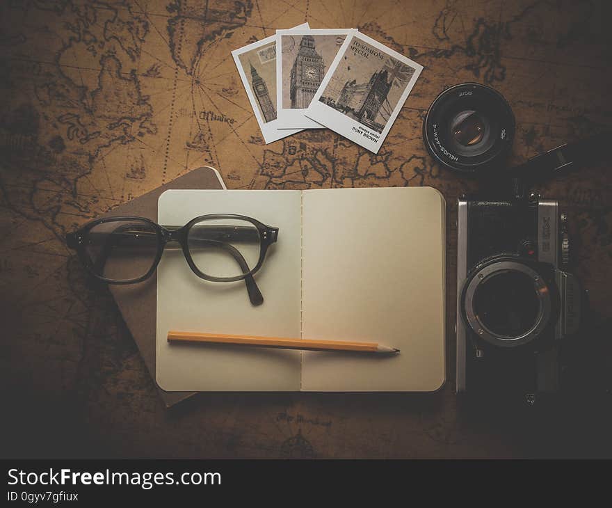 Black Framed Eyeglasses on White Empty Book