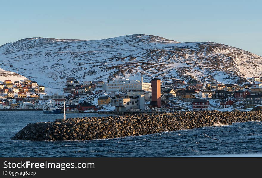 A rocky dock and a coastal town in winter. A rocky dock and a coastal town in winter.