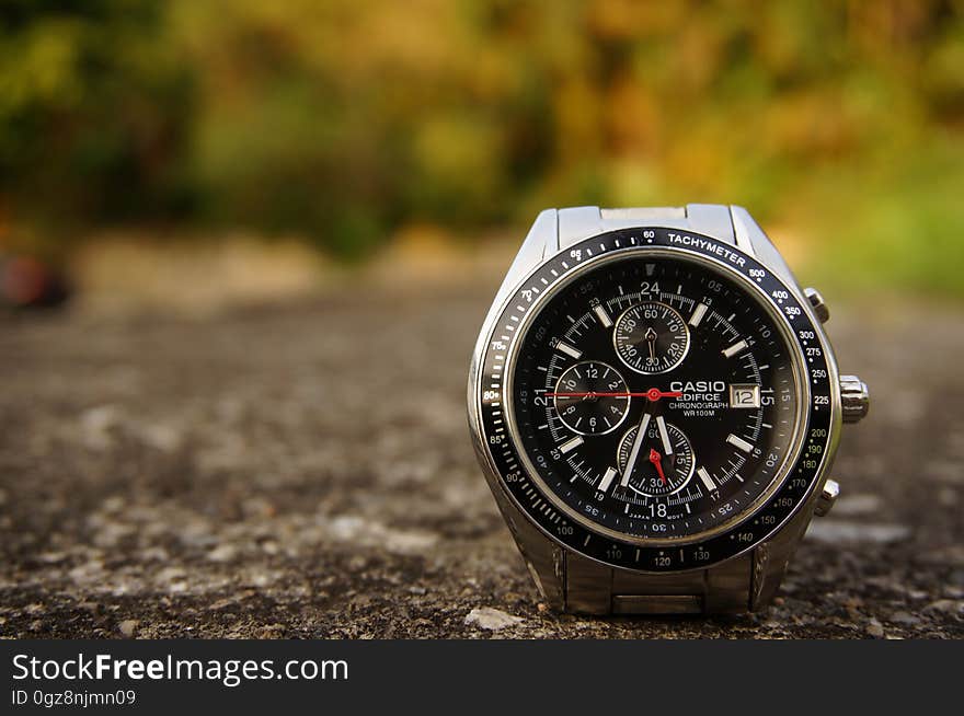 Closeup of sophisticated Casio wrist watch with multiple features on a path with a background of colorful Autumn leaves. Closeup of sophisticated Casio wrist watch with multiple features on a path with a background of colorful Autumn leaves.