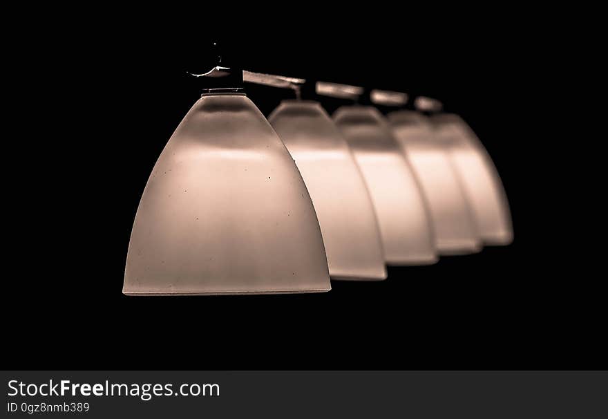 A row of frosted glass lamp shades. A row of frosted glass lamp shades.