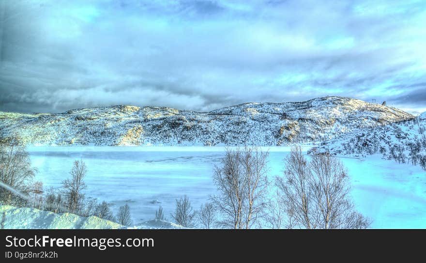 A panoramic view of a frozen mountain lake.