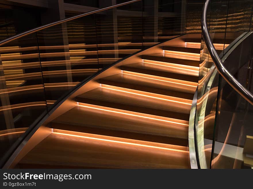 An illuminated staircase surrounded by glass railings.