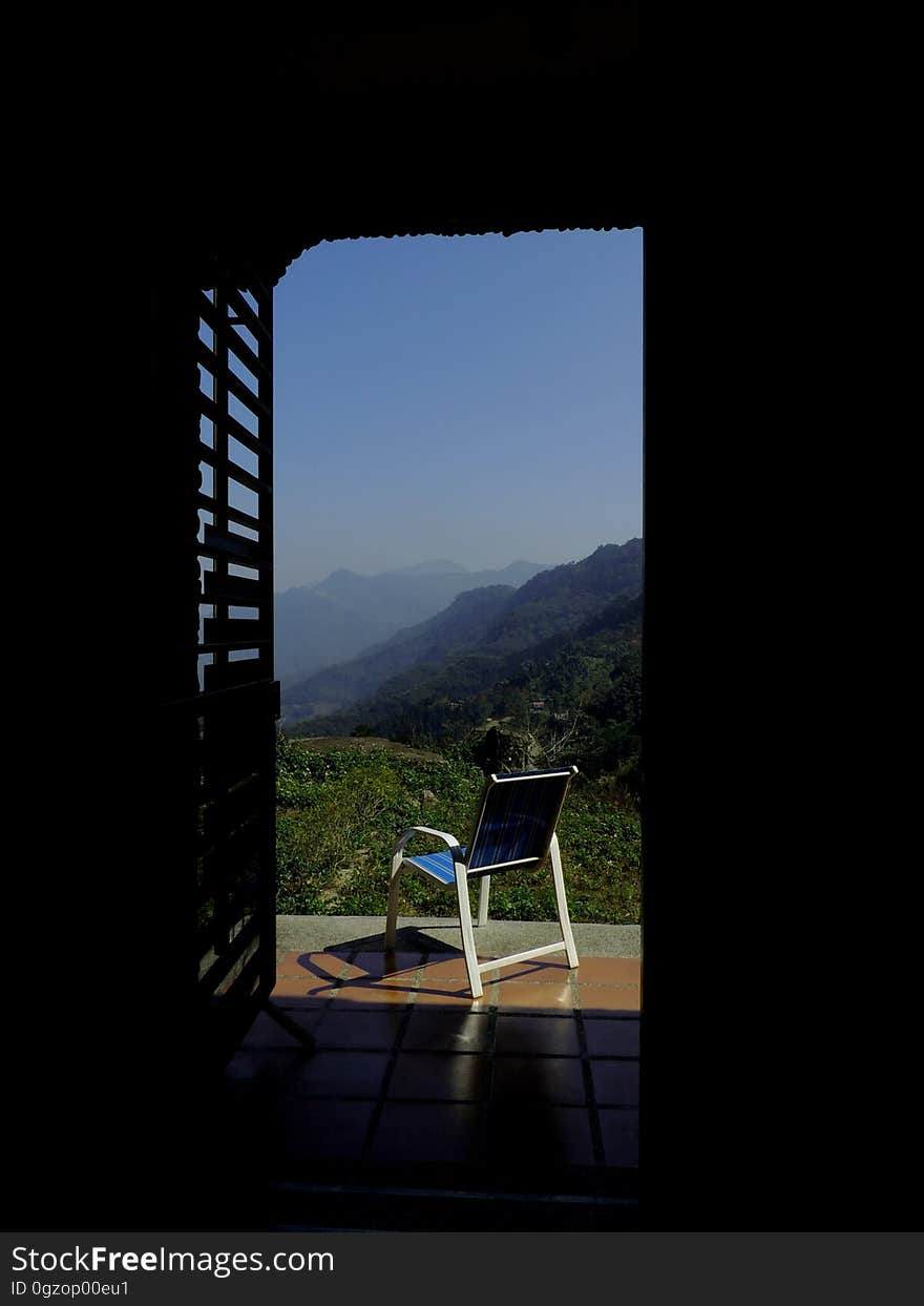 Blue and White Empty Armchair during Daytime Outside With Mountain Range Under Blue Sky during Daytime