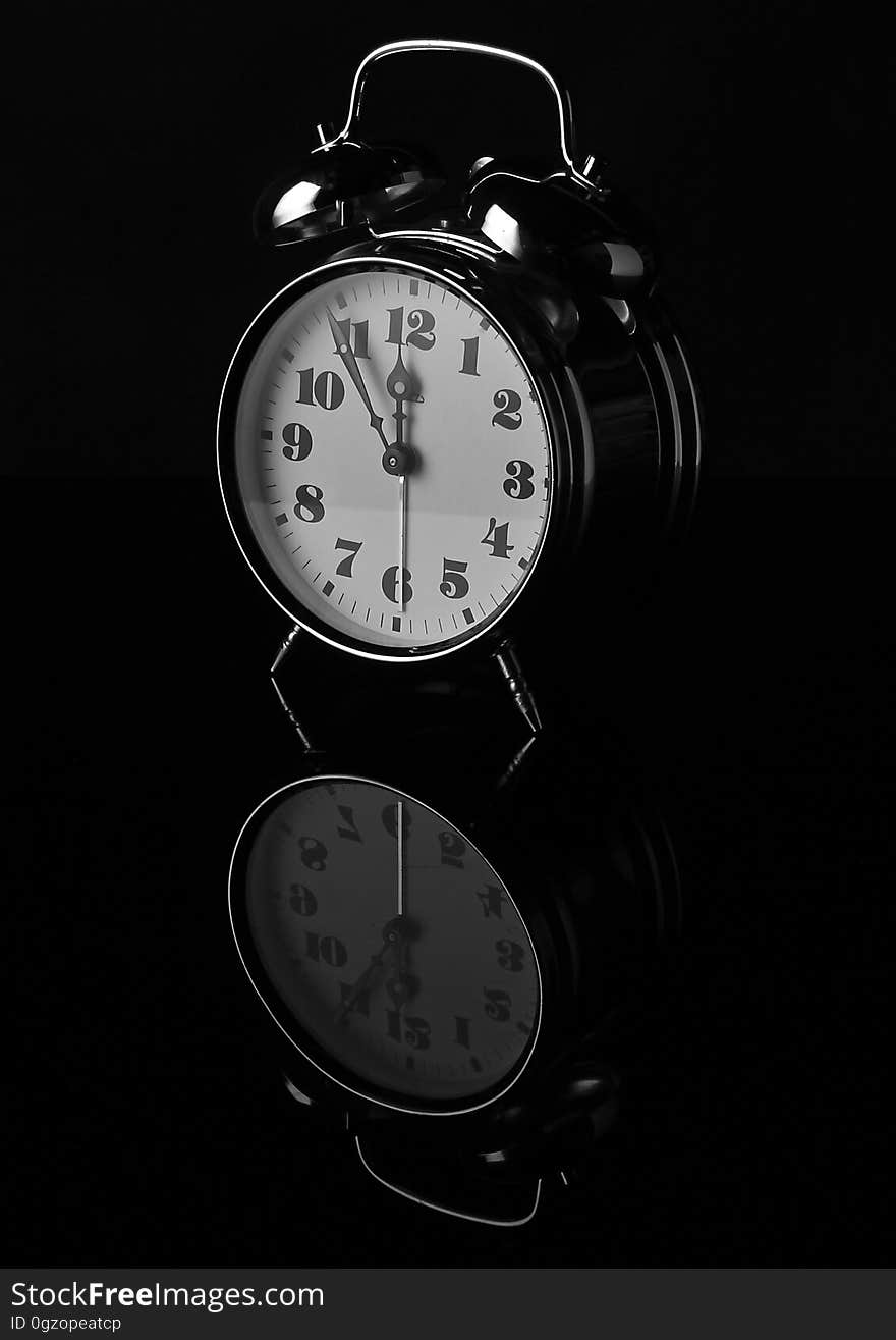 Close up of vintage analog alarm clock on black with reflection. Close up of vintage analog alarm clock on black with reflection.