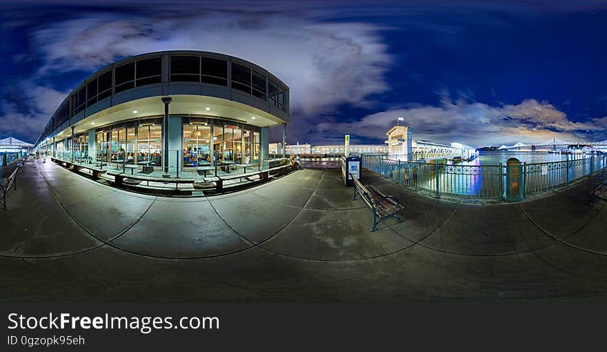 Illuminated glass windows on building along waterfront at night. Illuminated glass windows on building along waterfront at night.