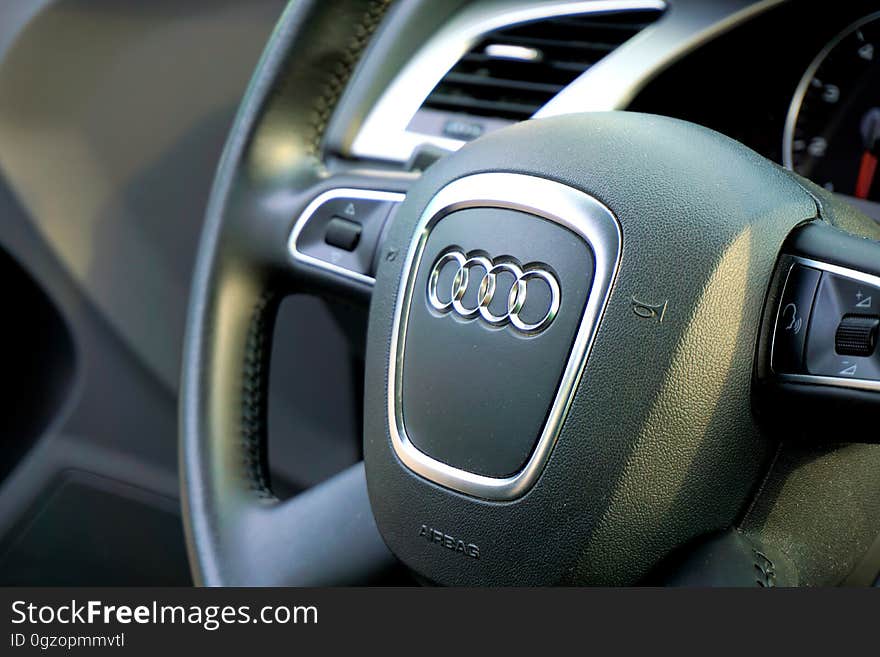 Close up of Audi logo on leather steering wheel automotive interior. Close up of Audi logo on leather steering wheel automotive interior.