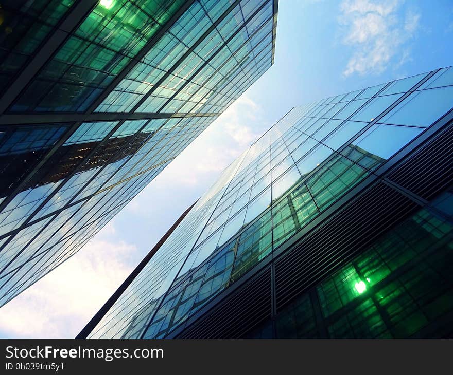 Glass and steel modern architecture from low angel against blue skies with white clouds. Glass and steel modern architecture from low angel against blue skies with white clouds.