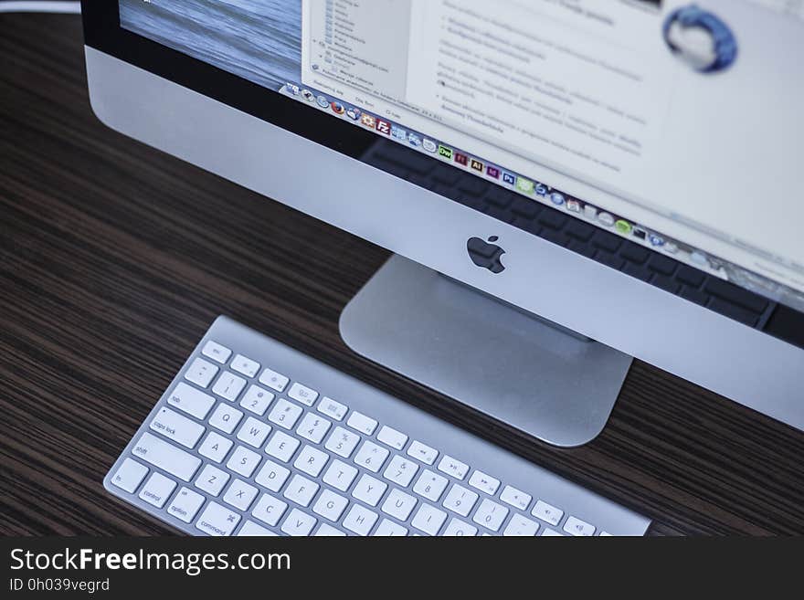 Apple logo on computer with keyboard on desk. Apple logo on computer with keyboard on desk.