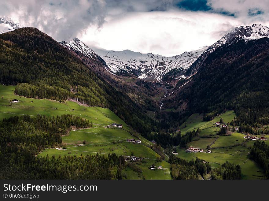 Town in green fields of mountain valley with fog or clouds. Town in green fields of mountain valley with fog or clouds.