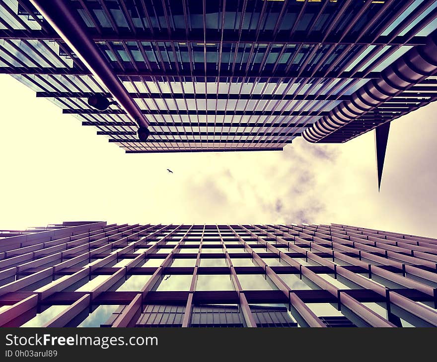 Front of glass and steel modern high rise buildings in sepia against cloudy skies. Front of glass and steel modern high rise buildings in sepia against cloudy skies.