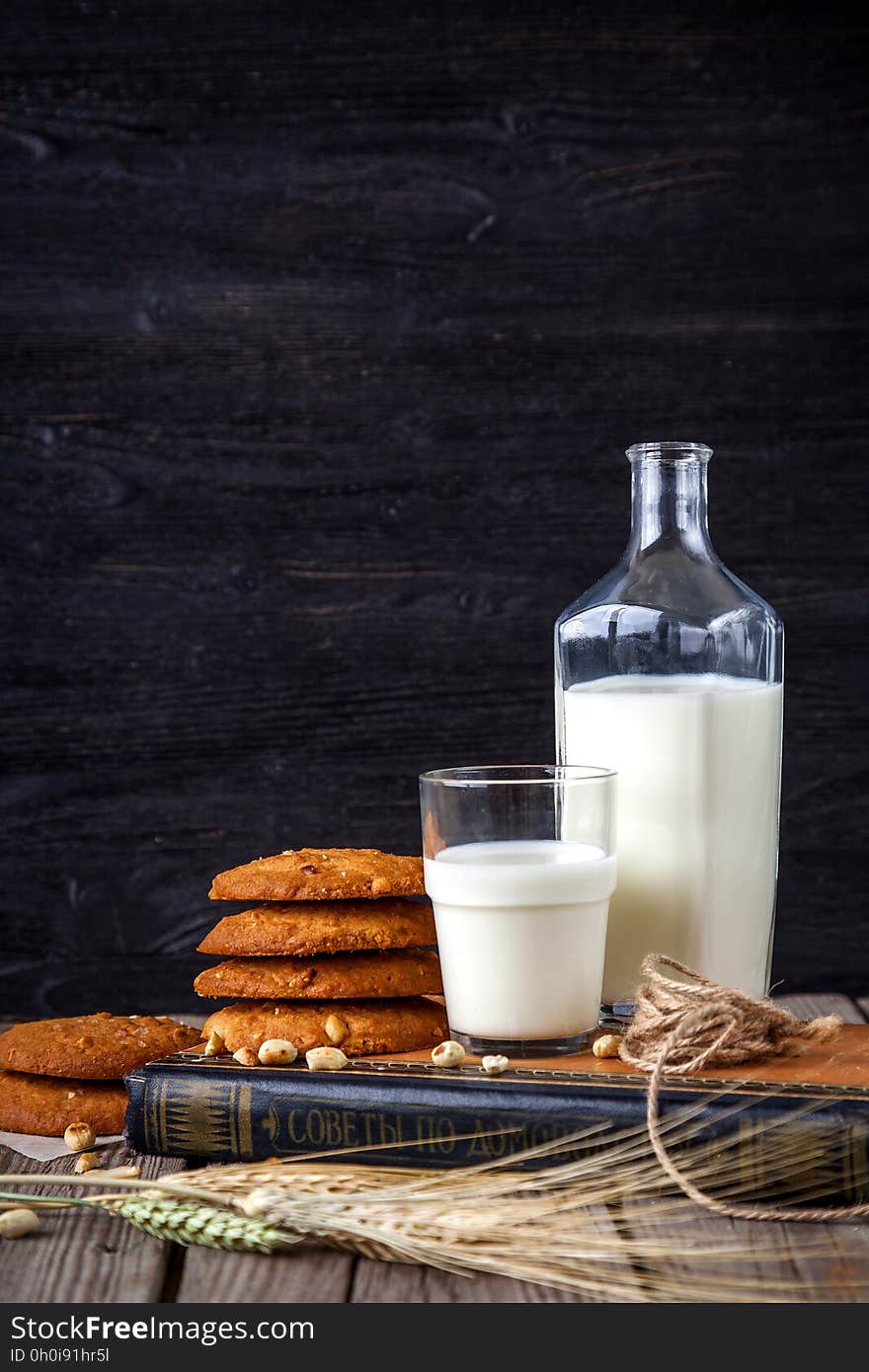 A pile of cookies with a bottle of milk and a glass of milk. A pile of cookies with a bottle of milk and a glass of milk.