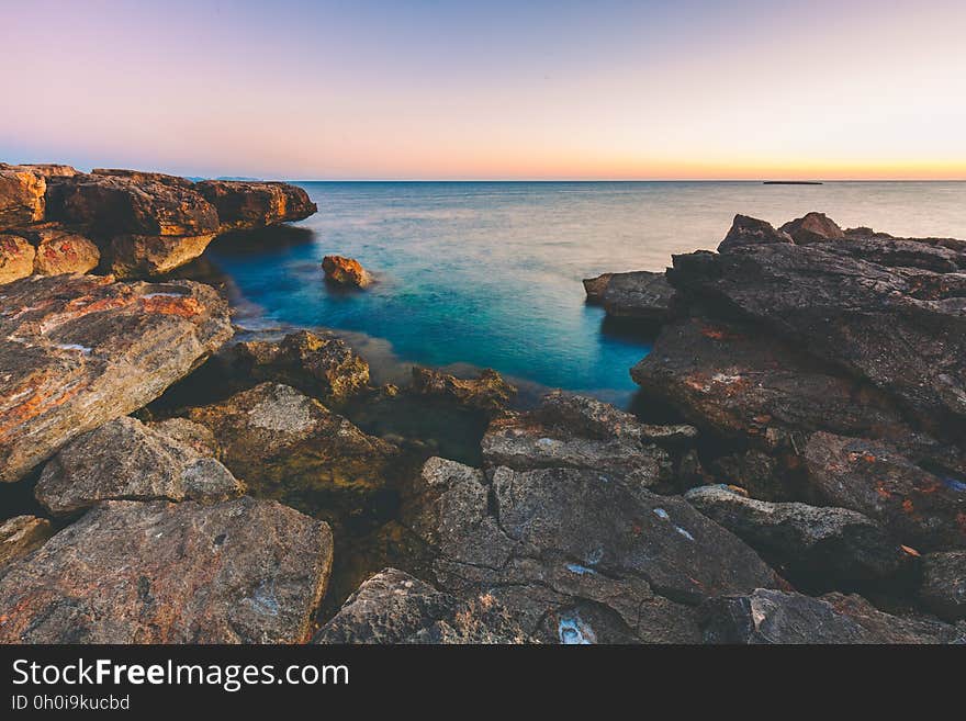 A rocky sea coast at sunset. A rocky sea coast at sunset.