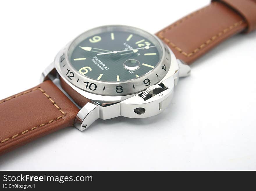 A close up of a luxury automatic watch with brown leather strap. A close up of a luxury automatic watch with brown leather strap.