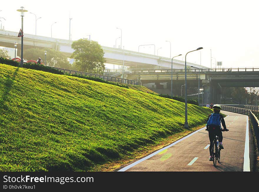 A man cycling along a cycling lane in a city. A man cycling along a cycling lane in a city.