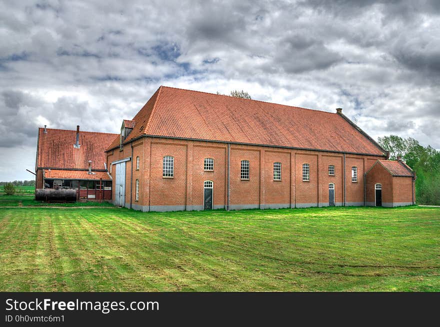 Brick farmhouse or barn in green rural field. Brick farmhouse or barn in green rural field.