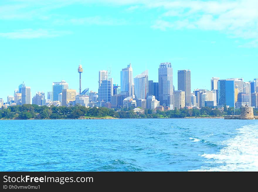 Skyline of modern city with high rise buildings along waterfront on sunny day. Skyline of modern city with high rise buildings along waterfront on sunny day.