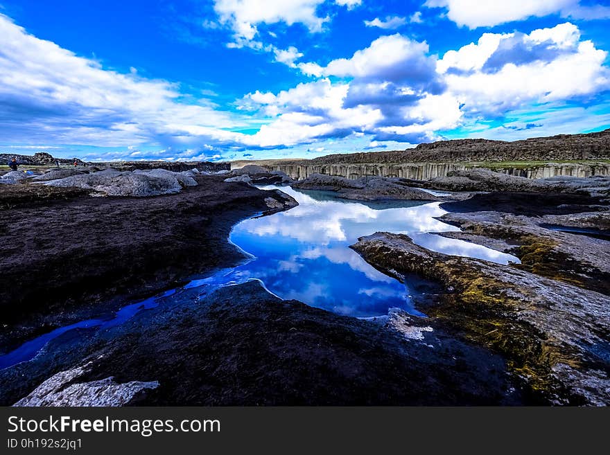 Clouds in blue skies reflecting in waterway in countryside. Clouds in blue skies reflecting in waterway in countryside.