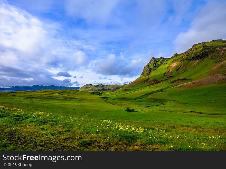 Green fields in landscape with hills against blue skies on sunny day. Green fields in landscape with hills against blue skies on sunny day.