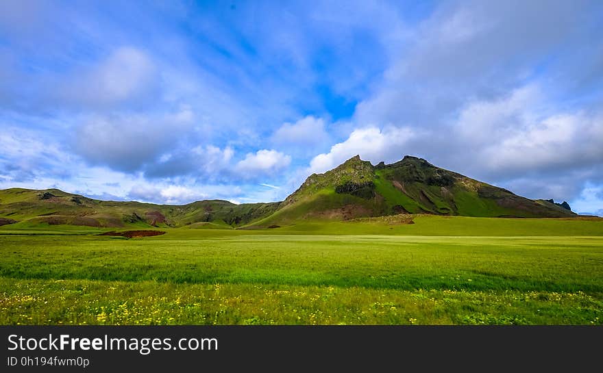 A landscape with green fields and mountains. A landscape with green fields and mountains.