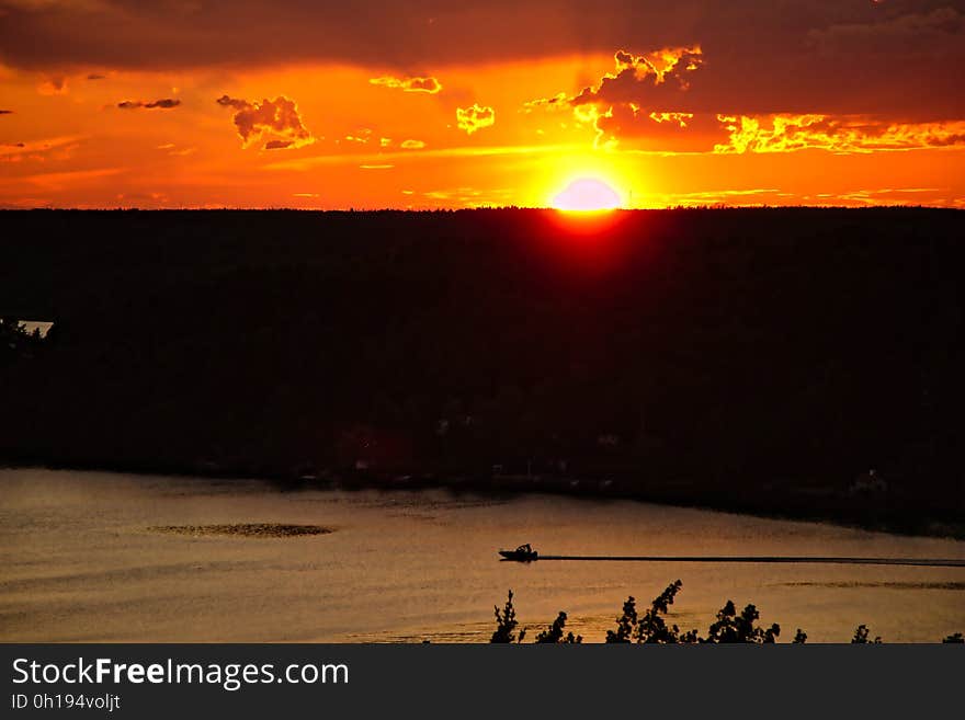 A high vantage point view over water with sun setting in the distance. A high vantage point view over water with sun setting in the distance.