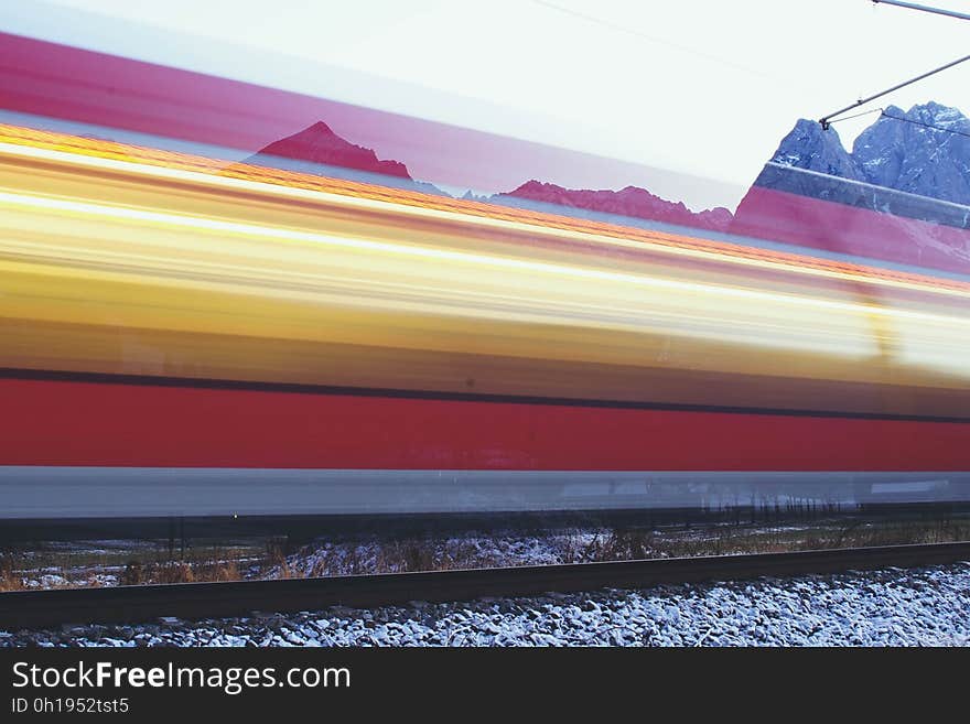 A train moving past a scenic mountainscape.