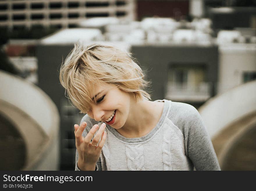 A girl with a short blonde hair laughing. A girl with a short blonde hair laughing.