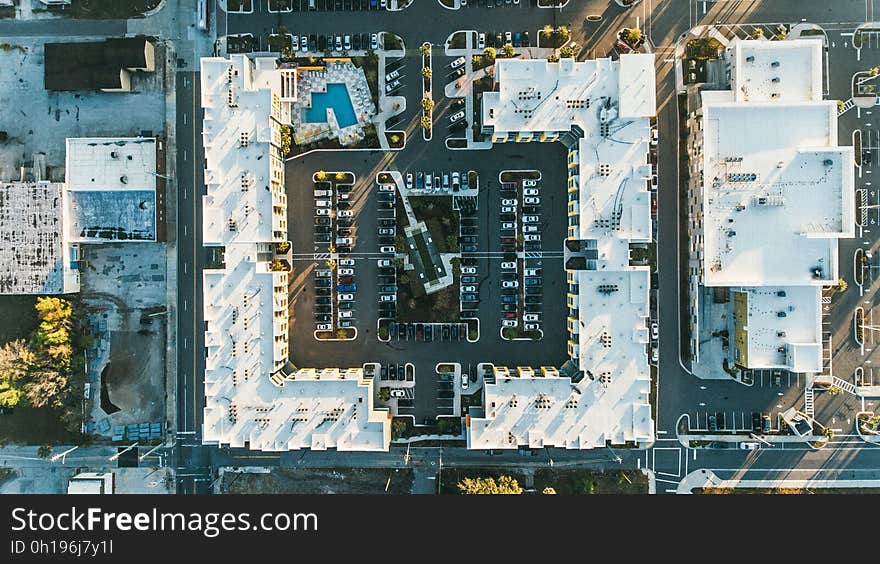 An aerial view of a block of buildings with a parking lot. An aerial view of a block of buildings with a parking lot.