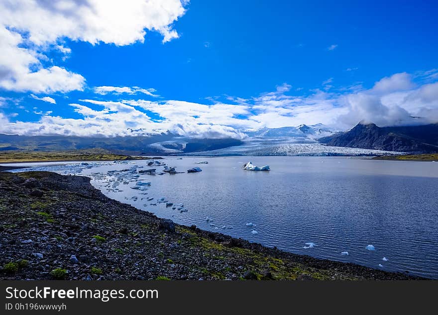 The shore of the sea or an inlet with rocky shores and mountains in the distance. The shore of the sea or an inlet with rocky shores and mountains in the distance.