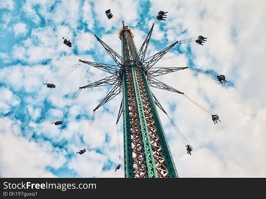 A carnival ride with swinging chairs around a tall pole.